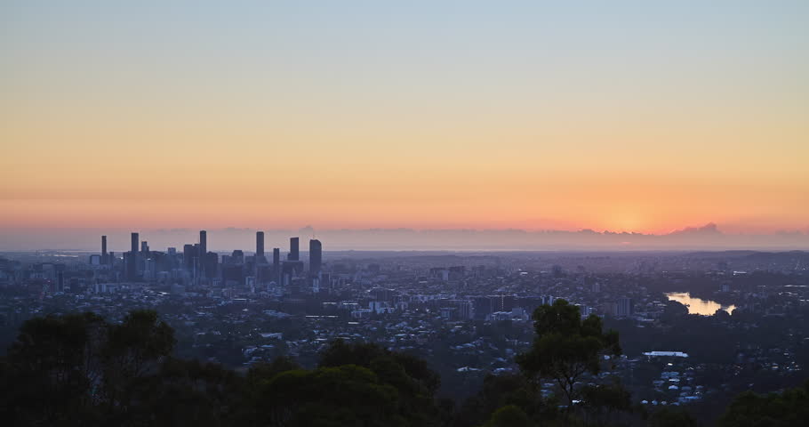 4K locked off stationary Time Lapse motion view of Brisbane Central Business District at dawn with the rising sun in background, Brisbane, Queensland, Australia