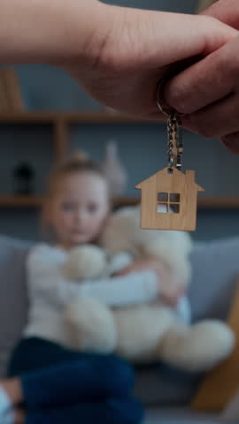 Happy Caucasian family relocation buying new home couple parents hands holding keys daughter child kid playing on background custody adoption insurance mortgage loan concept credit bank moving day