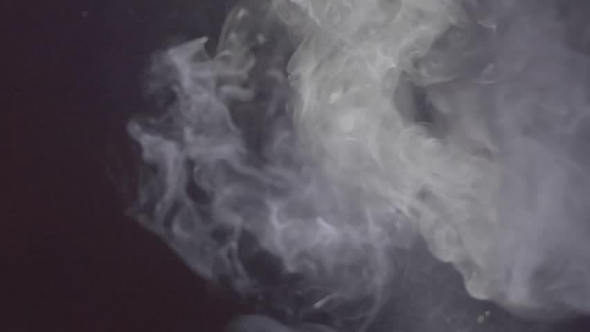 white smoke plumes on a black background, close-up, slow motion