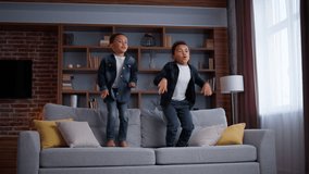 Happy little boys African American sons jumping on couch at home, naughty noisy bad behavior carefree ethnic siblings children friends brothers kids jump on sofa in living room enjoy playing game fun - Powered by Shutterstock - Get 15% off with code: PIKWIZARD15