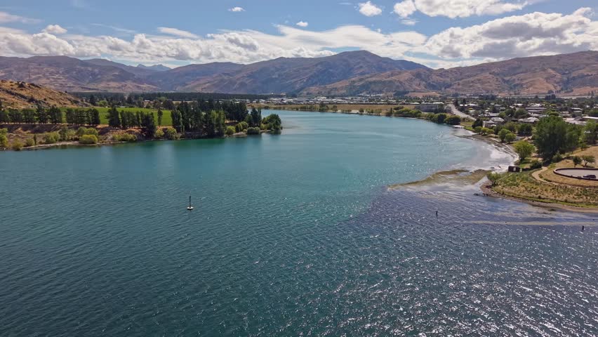 Aerial shot over junction of Clutha and Kawarau Rivers with mountains