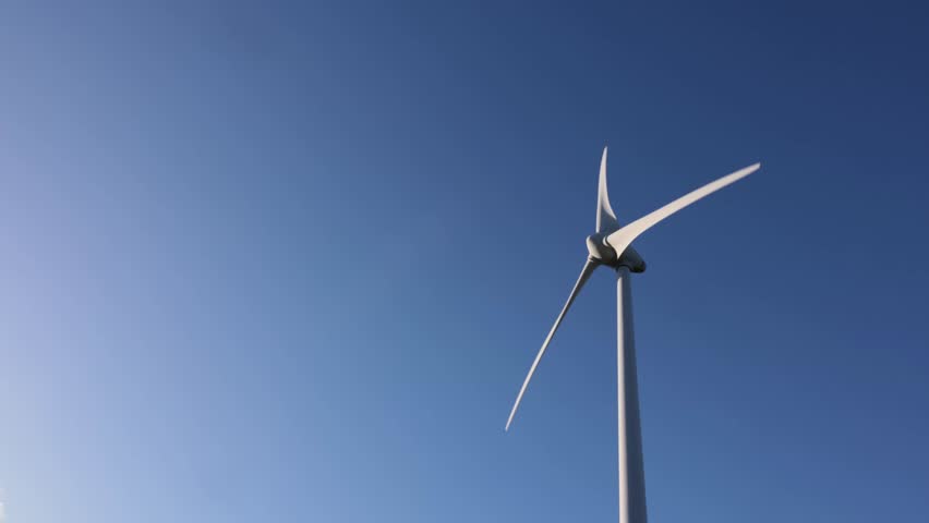 Horizontal shot: turbine rotating against an azure sky with scattered clouds. Crisp, natural look with copy space. Perfect for climate, energy, and sustainability stories, 4K