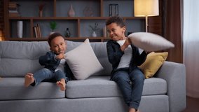Two naughty African American boys fighting with pillows little active positiv sons kids siblings brothers children enjoying game in living room home having fun battle laughing smiling joy childhood - Powered by Shutterstock - Get 15% off with code: PIKWIZARD15