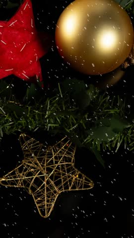 Animation of snow falling against christmas decoration with baubles. christmas celebration festivity concept digitally generated image.