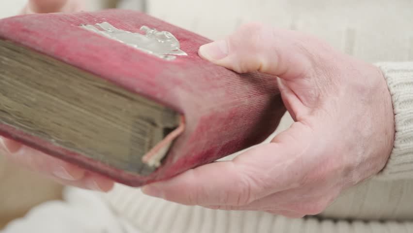 male hands leafing through pages of an old photo album, black and white photographs, evoking nostalgia and cherished memories past, family history and forgotten moments, genealogy archive