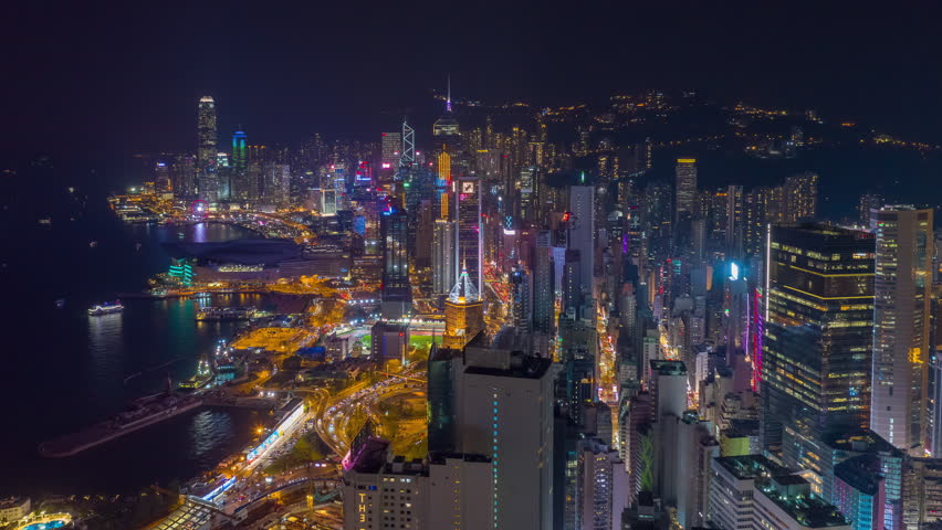 night illuminated flight over hong kong city downtown traffic bay aerial panorama 4k timelapse