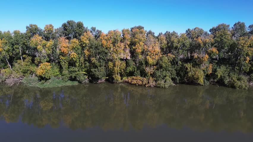 Aerial view over a wide river in autumn. Peace and tranquility in nature.