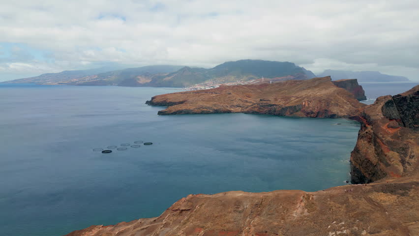 Aerial ocean rocks view in cloudy day. Serene travel destination in summer drone. Calm azure water washing amazing sea cliffs under gloomy sky. Rough island coastline turquoise water. Tourism concept