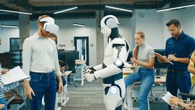 Man wearing VR headset controlling humanoid robot. Team of coworkers observing experiment and taking notes during tech presentation. Group testing innovative robotics project together in office lab. - Powered by Shutterstock - Get 15% off with code: PIKWIZARD15