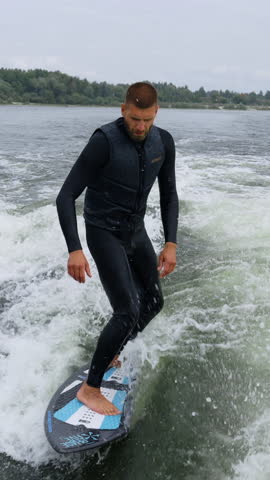 A Surfer Riding the Wake: Captured Moments of Thrilling Water Sports Action on a Surfboard as He Glides Over Waves with Skill and Grace