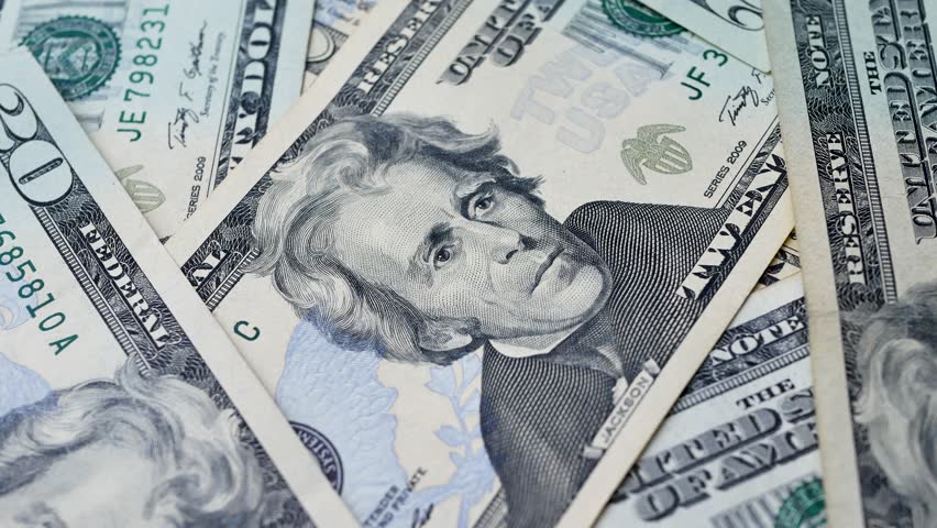 Several 20 dollar bills stacked on each other with portrait of Andrew Jackson visible. Paper currency used as legal tender for payments in domestic and international transactions 