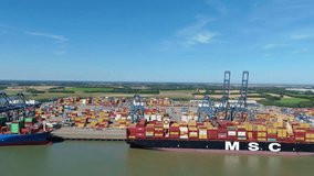 Cinematic drone footage of a busy shipping port in England, showing cranes, containers, and tankers in motion. - Powered by Shutterstock - Get 15% off with code: PIKWIZARD15