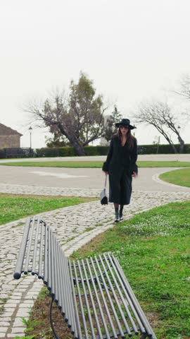 Elegant Woman Arriving At The Green Park And Sitting On The Bench 