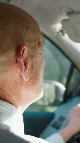Elderly Man Driving the Car on a Sunny Day 