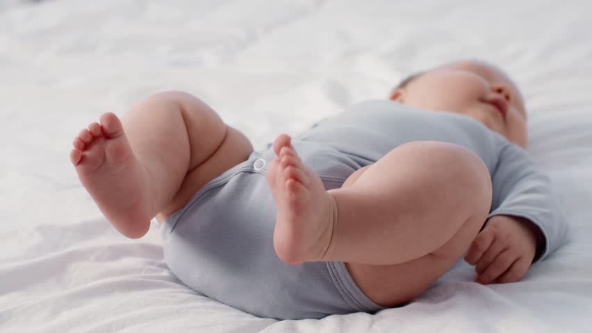 Cherubic baby peacefully resting on a soft surface at home with loving care