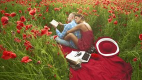 Romantic couple enjoying time together in a blooming poppy field. Woman resting on man s shoulder while he reads a book. Relaxing summer picnic with red flowers, typewriter, and hat. - Powered by Shutterstock - Get 15% off with code: PIKWIZARD15