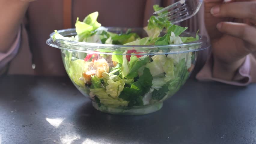 Woman eating a salad outdoors 4k