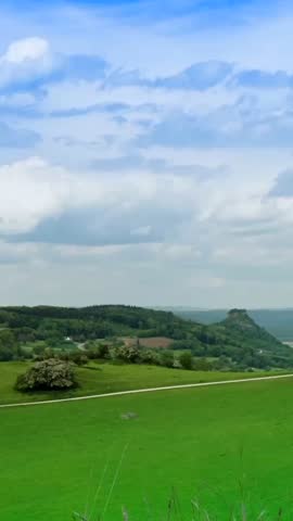 Scenic countryside view with rolling hills and clouds in the background during a clear day