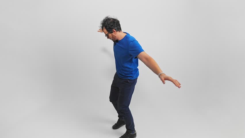 Back view of a Caucasian man walking on a narrow path holding hands by sides to keep balance and trying not to fall. Guy is stepping on an invisible rope being very careful filmed on white background.