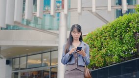 Young business businesswoman walking outdoor near modern office buildings, using mobile phone for travel, focused on technology communication on city street. - Powered by Shutterstock - Get 15% off with code: PIKWIZARD15