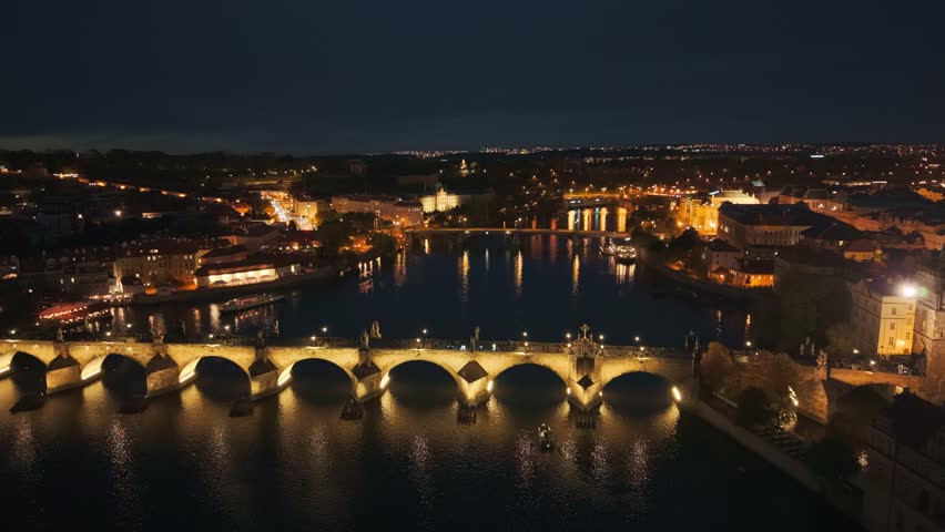 Aerial night view of Charles Bridge and Prague Castle over Vltava River, Czech Republic