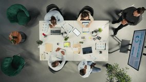 Top down view of diverse colleagues and managers participating in briefing. Business meeting focuses on negotiation, reporting and resource allocation for corporate development and success. Camera A. - Powered by Shutterstock - Get 15% off with code: PIKWIZARD15