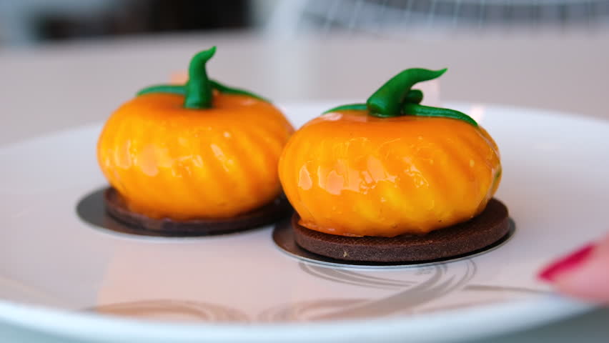 Left to right zenithal pan showing Halloween shaped cookies, cups and plates with pumpkin motifs. Warm and autumnal composition with focus on cookies.