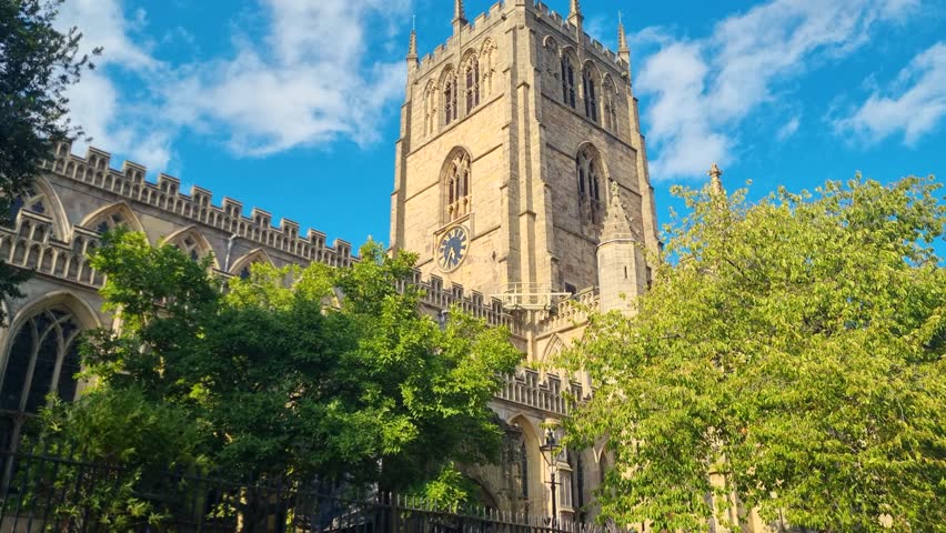 Revealing view of St. Mary’s Church in Nottingham, United Kingdom, showcasing its sunlit bell tower rising gracefully against a clear blue sky