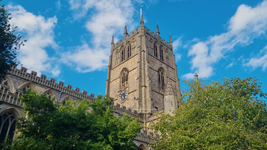 Sunlit bell tower of St. Mary’s Church in Nottingham, UK, standing tall against a clear blue sky and highlighting the church’s elegant architecture