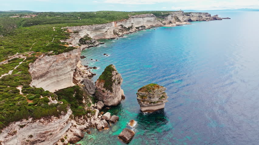 Aerial drone shot over the stunning rugged coastline of southern Corsica, France.