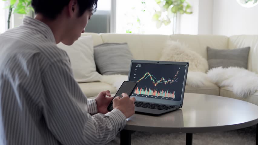 Asian man rejoicing at rising stock prices