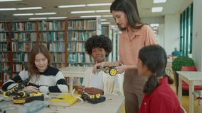 Female teacher teaching high school students in a robotics and technology class, collaboratively building a robot for a engineering project - Powered by Shutterstock - Get 15% off with code: PIKWIZARD15