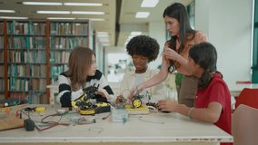 Female teacher teaching high school students in a robotics and technology class, collaboratively building a robot for a engineering project - Powered by Shutterstock - Get 15% off with code: PIKWIZARD15