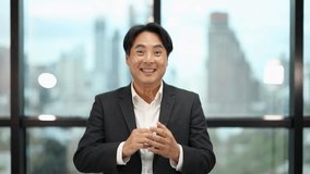 Asian businessman in formal suit claps and smiles, natural daylight, cityscape office background, static shot - Powered by Shutterstock - Get 15% off with code: PIKWIZARD15