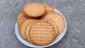 A plate of wheat biscuits is placed on a concrete surface, showcasing a simple snack option. - Powered by Shutterstock - Get 15% off with code: PIKWIZARD15
