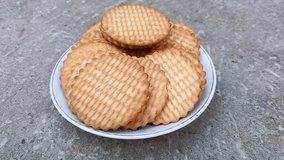 A plate of wheat biscuits is placed on a concrete surface, showcasing a simple snack option. - Powered by Shutterstock - Get 15% off with code: PIKWIZARD15