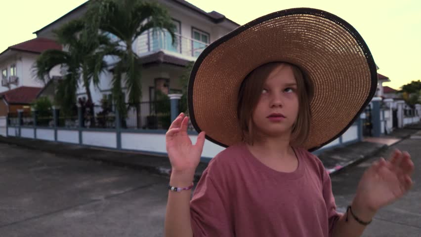 Portrait of Teenage Girl in Straw Hat Walking in Suburbs