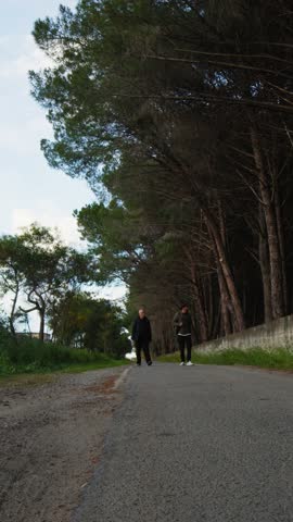 Elderly Father and Son Walking on a Path Near the Woods