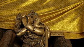 Bronze Ganesha Statue with Golden Cloth at Hindu Temple - Elephant God Holding Musical Instrument - Powered by Shutterstock - Get 15% off with code: PIKWIZARD15