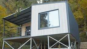 Group of minimalistic wooden cabins with panoramic windows located on a forest slope. Sustainable prefab architecture surrounded by colorful autumn trees.
 - Powered by Shutterstock - Get 15% off with code: PIKWIZARD15
