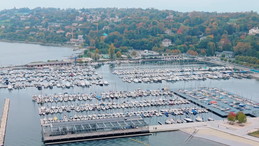 Aerial view of the many boats docked at Quai Gustave-Ador, their white hulls contrasting against the dark water, Port-Noir, Geneva, Switzerland.