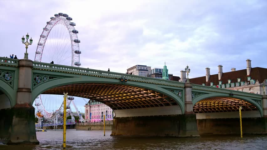 View of London city skyline from a floating boat on the River Thames, featuring famous landmarks and modern architecture under a bright sky. Iconic urban travel scene.