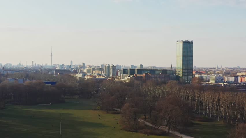 Aerial view of a park, trees, and buildings, with a tall skyscraper and the Berlin TV Tower visible in the distance, Berlin, Berlin, Germany.