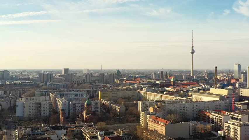 Aerial view of the Berliner Fernsehturm, a television tower rising above the urban landscape, contrasting with the city