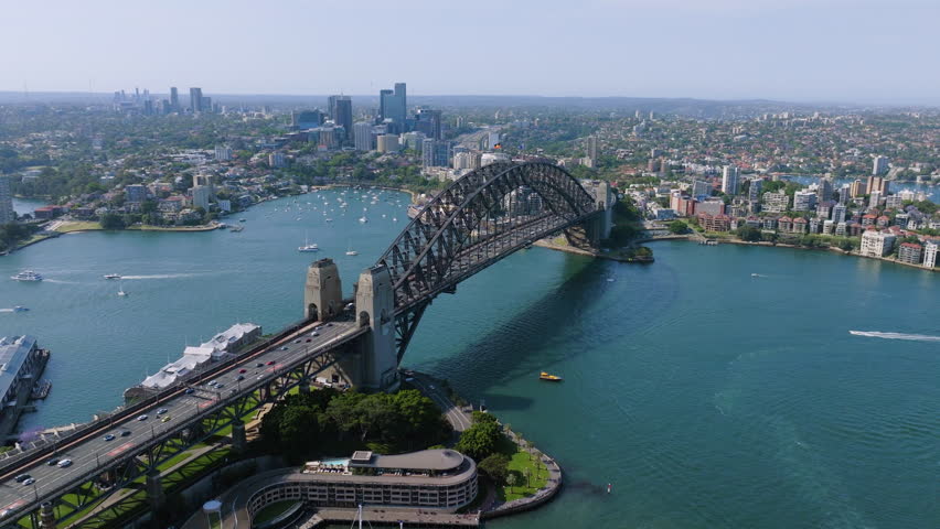 Panoramic drone shot orbiting the Harbour bridge, sunny day in Sydney, Australia