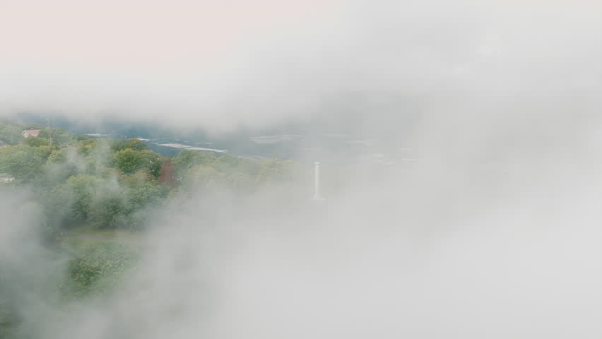 Clouds part to reveal the Point Park monument perched on Lookout Mountain, framed by fall foliage and valley views.