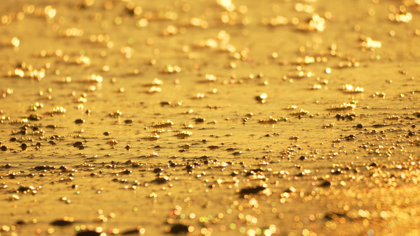 Golden Waves Beach, water washing over glistening sand at sunset, peaceful nature scene