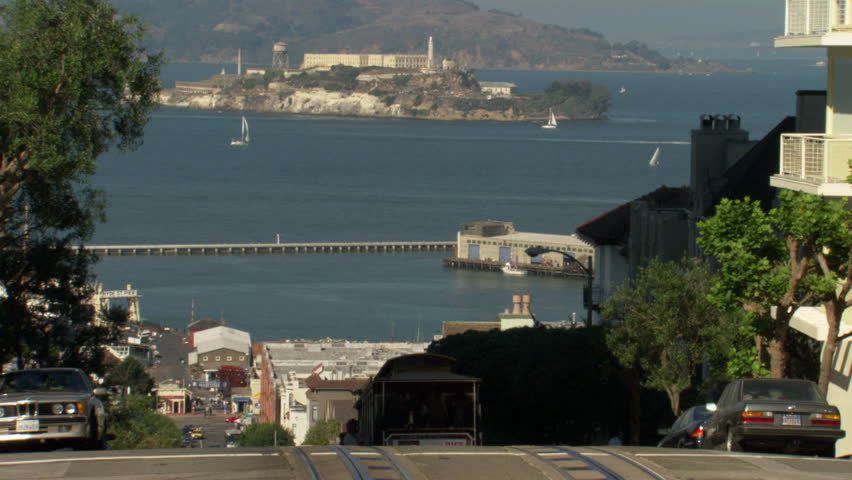Zoom into Alcatraz prison island in San Francisco Bay as seen from a hilltop