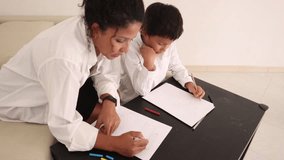 Mother helping son drawing on paper at home - Powered by Shutterstock - Get 15% off with code: PIKWIZARD15