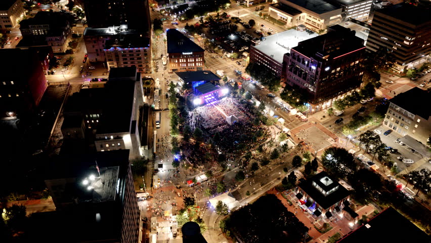 Downtown Chattanooga illuminated at night with thousands gathered around the Miller Plaza stage for live bluegrass performances.